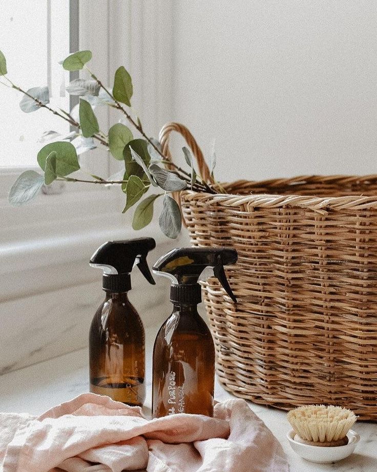 Cleaning sprays displayed with basket and dried herbs.