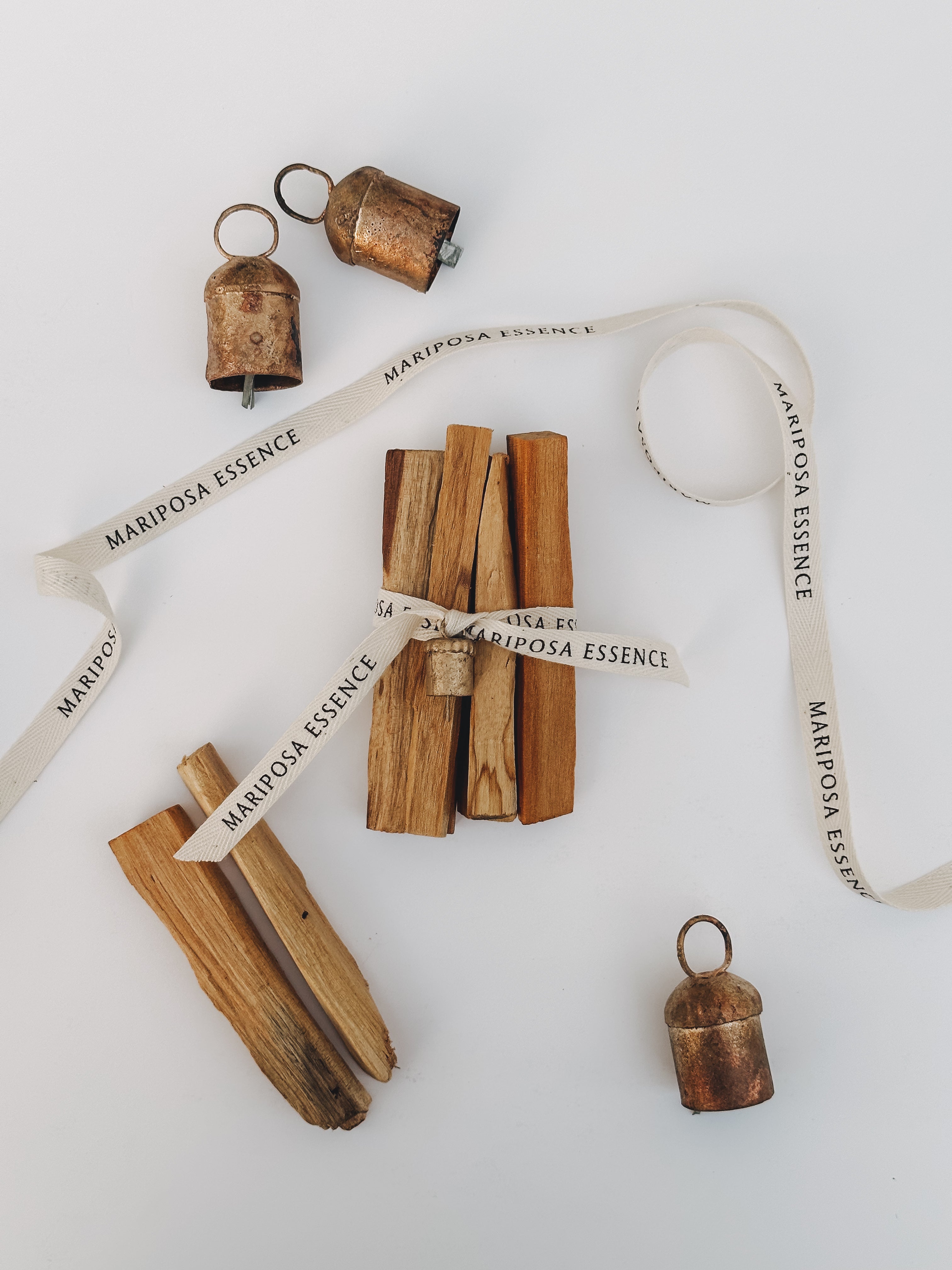Palo santo sticks bundled and wrapped with cotton ribbon and mini nana bell.