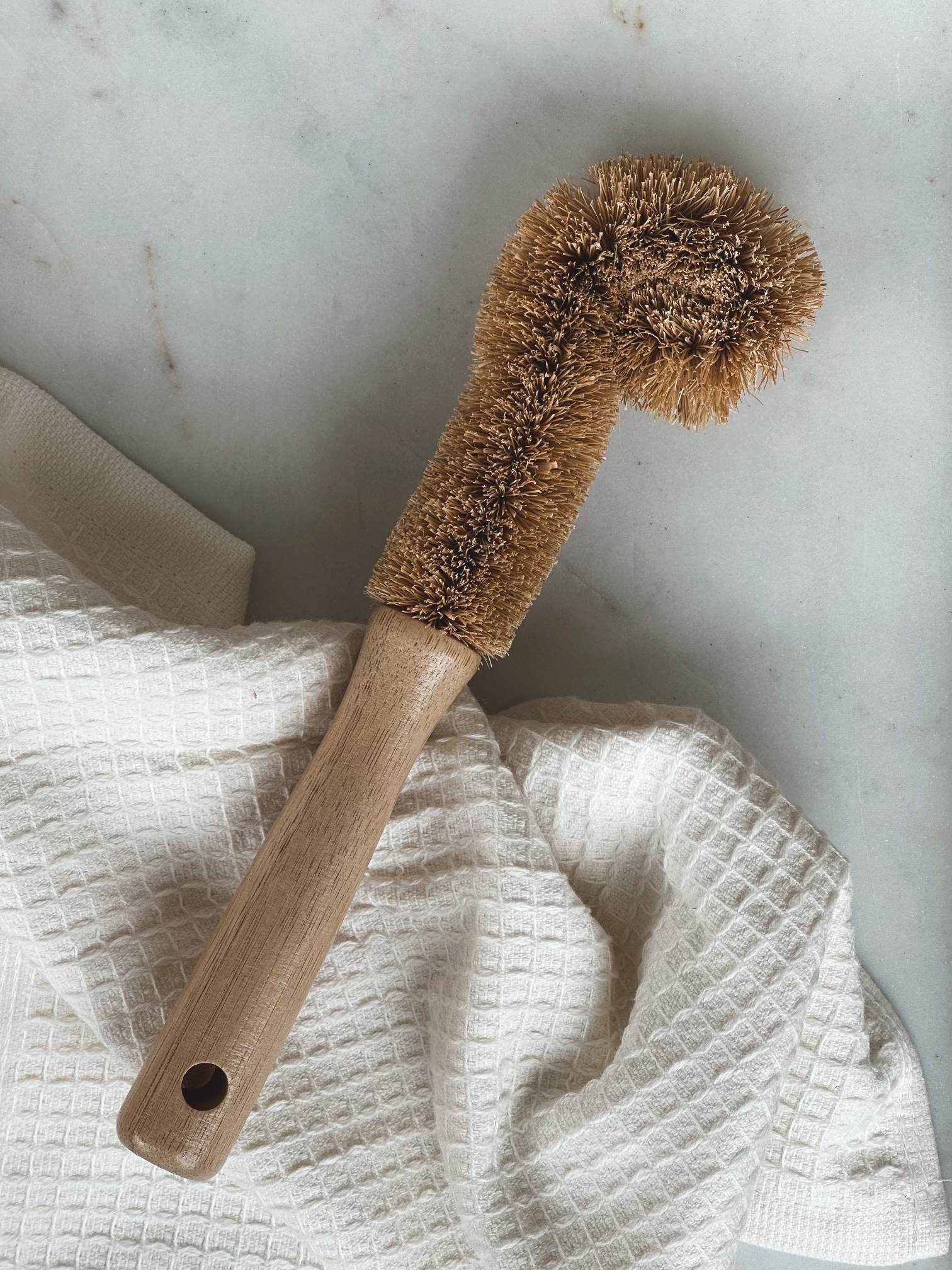 Coconut fiber bottle brush displayed with an ivory towel.