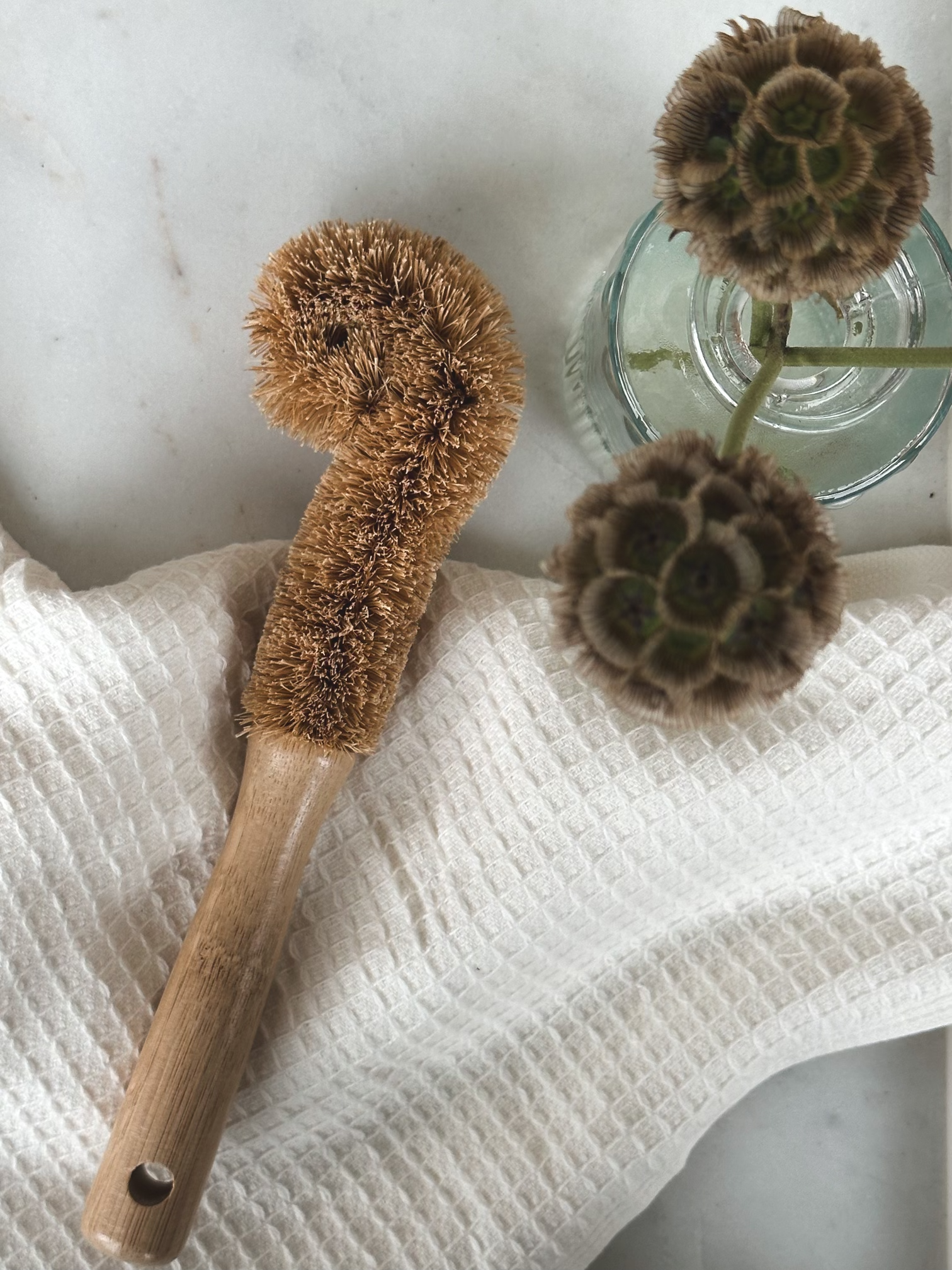 Bottle brush displayed on an ivory towel.