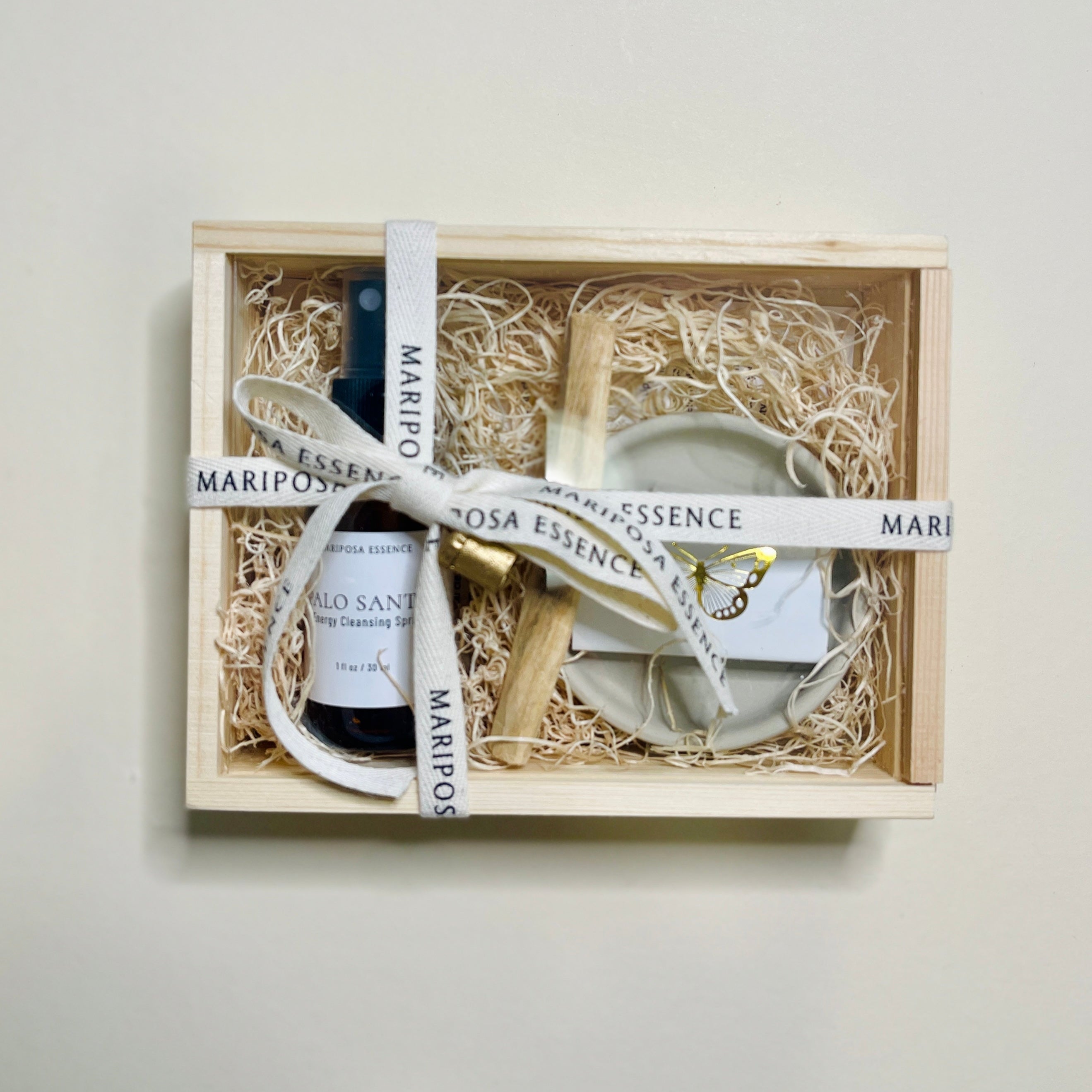 Palo Santo Starter Kit in a small wood box with clear top and mini spray, palo santo and palo santo holder with foiled gold butterfly matches.