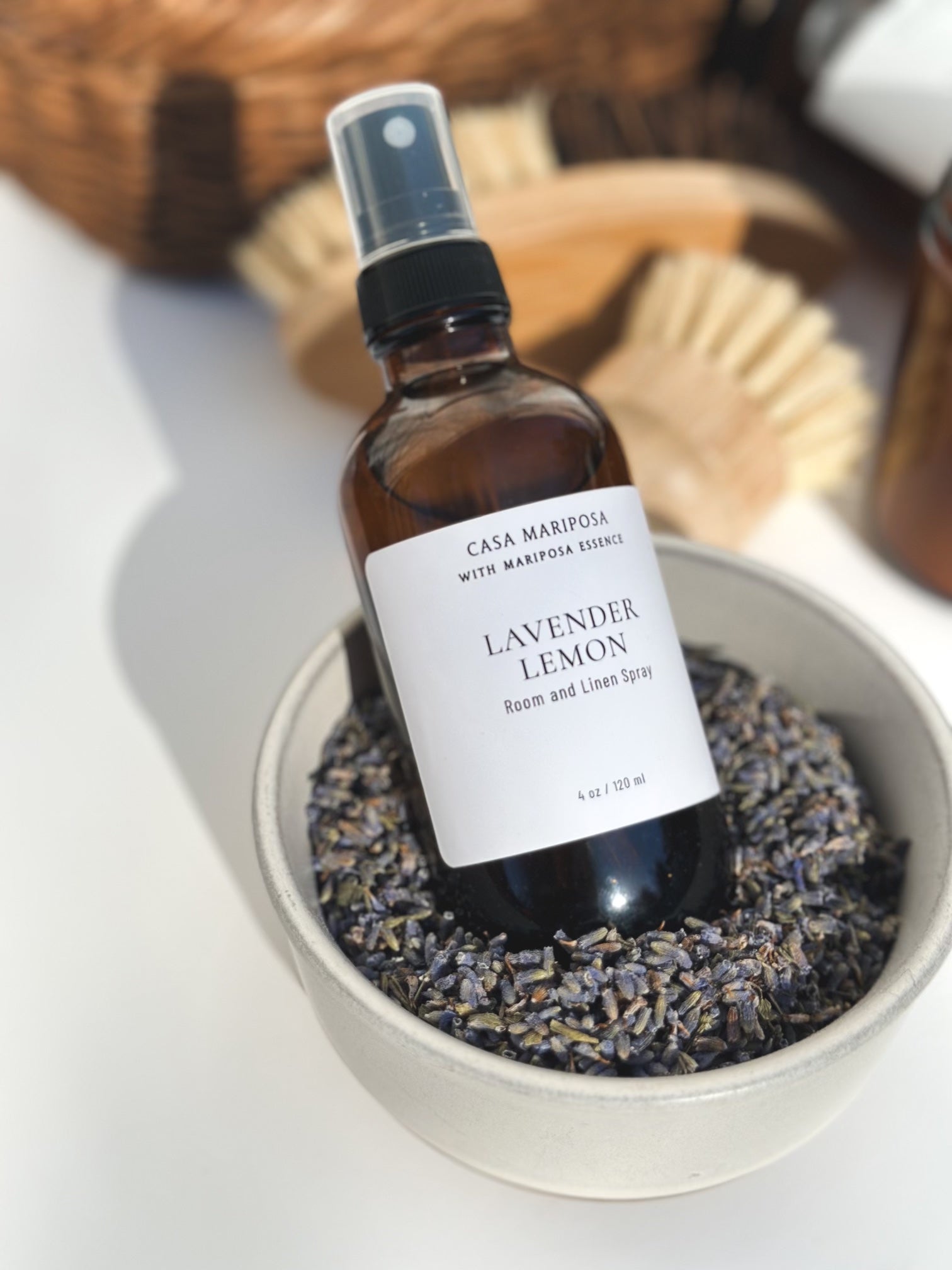 Lavender lemon room spray displayed with lavender flowers in a bowl