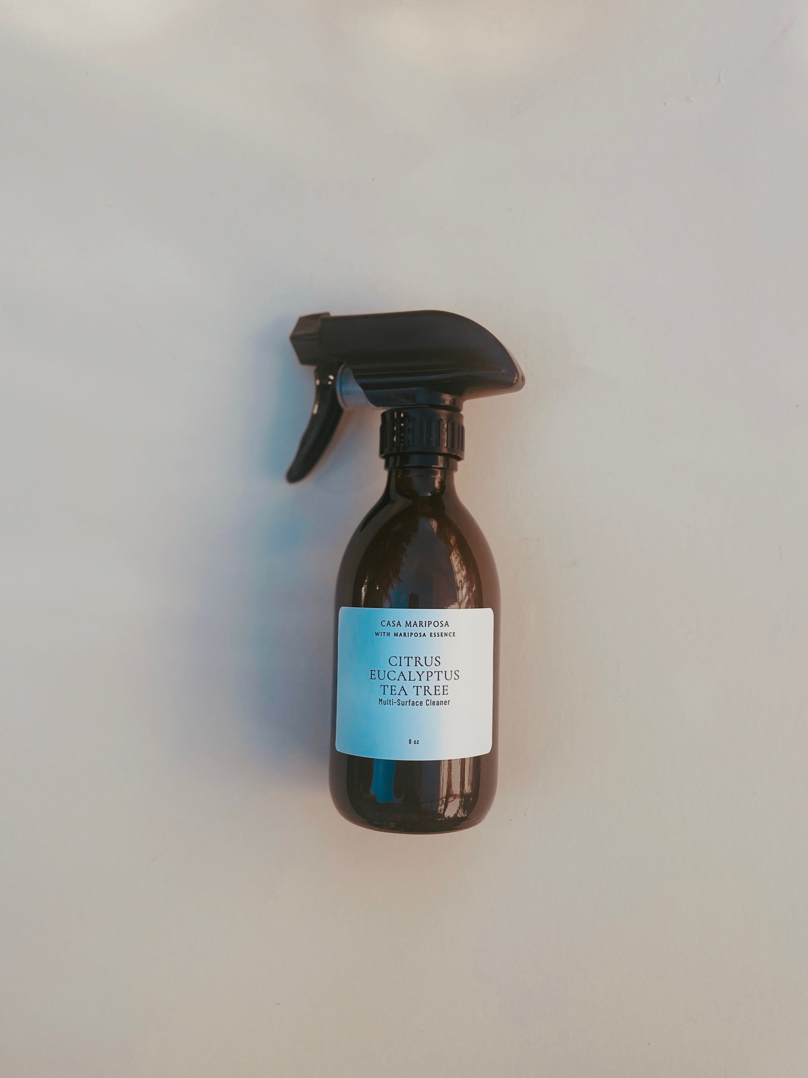 Amber glass spray bottle with a label on a light gray background