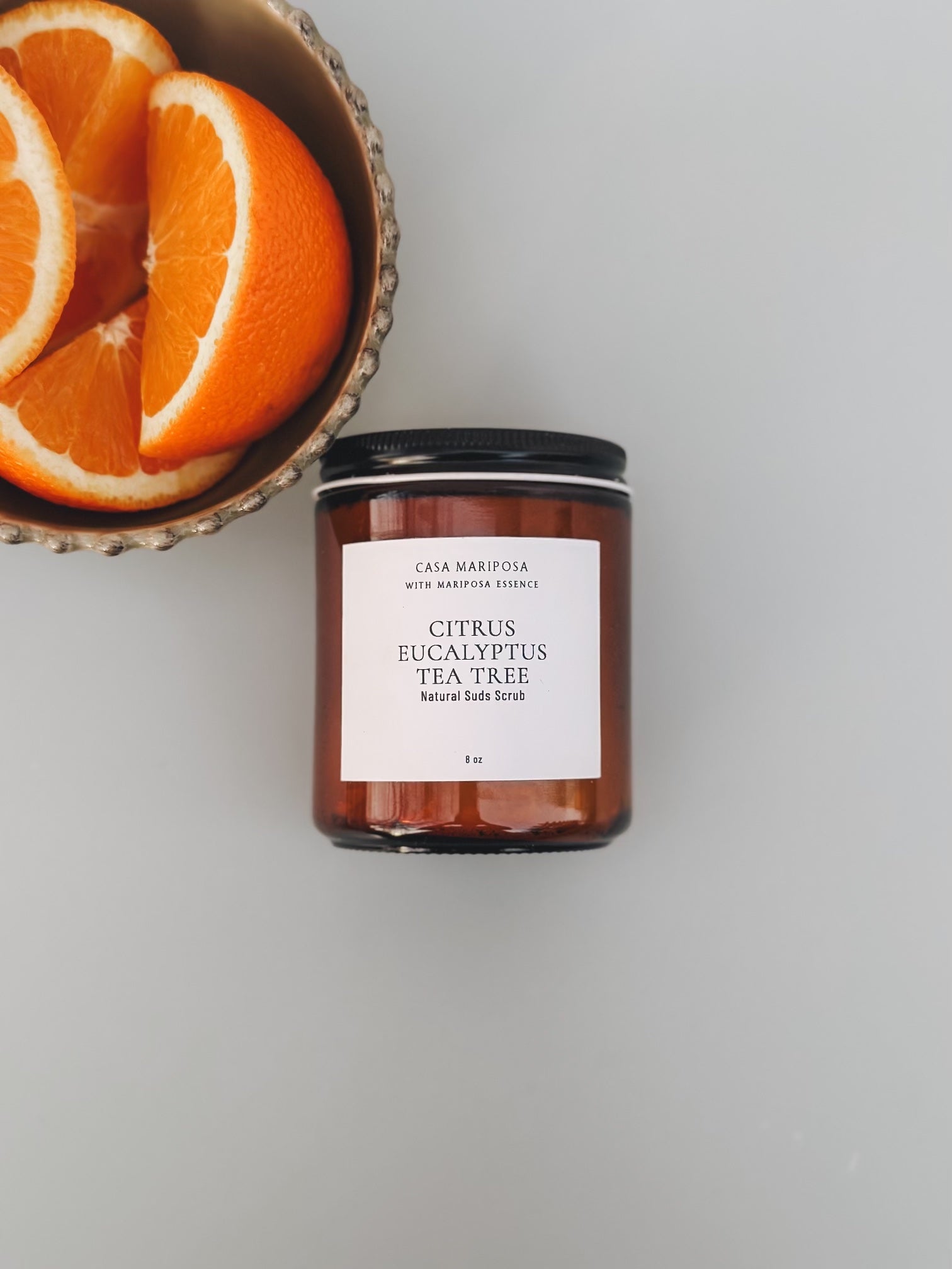 Citrus Eucalyptus Suds Scrub displaye with a bowl of oranges

