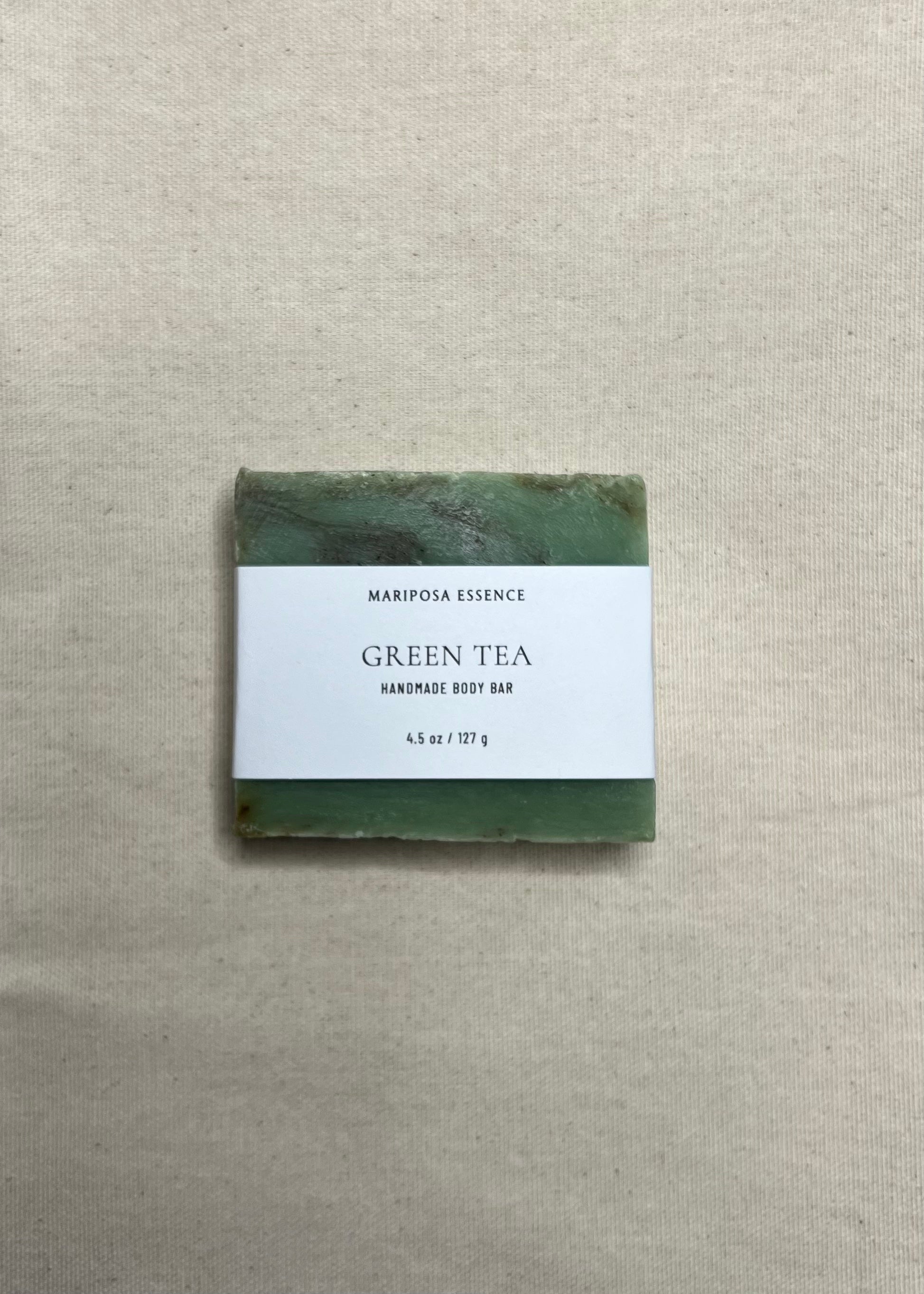 Green tea soap bar with a label on a beige fabric background