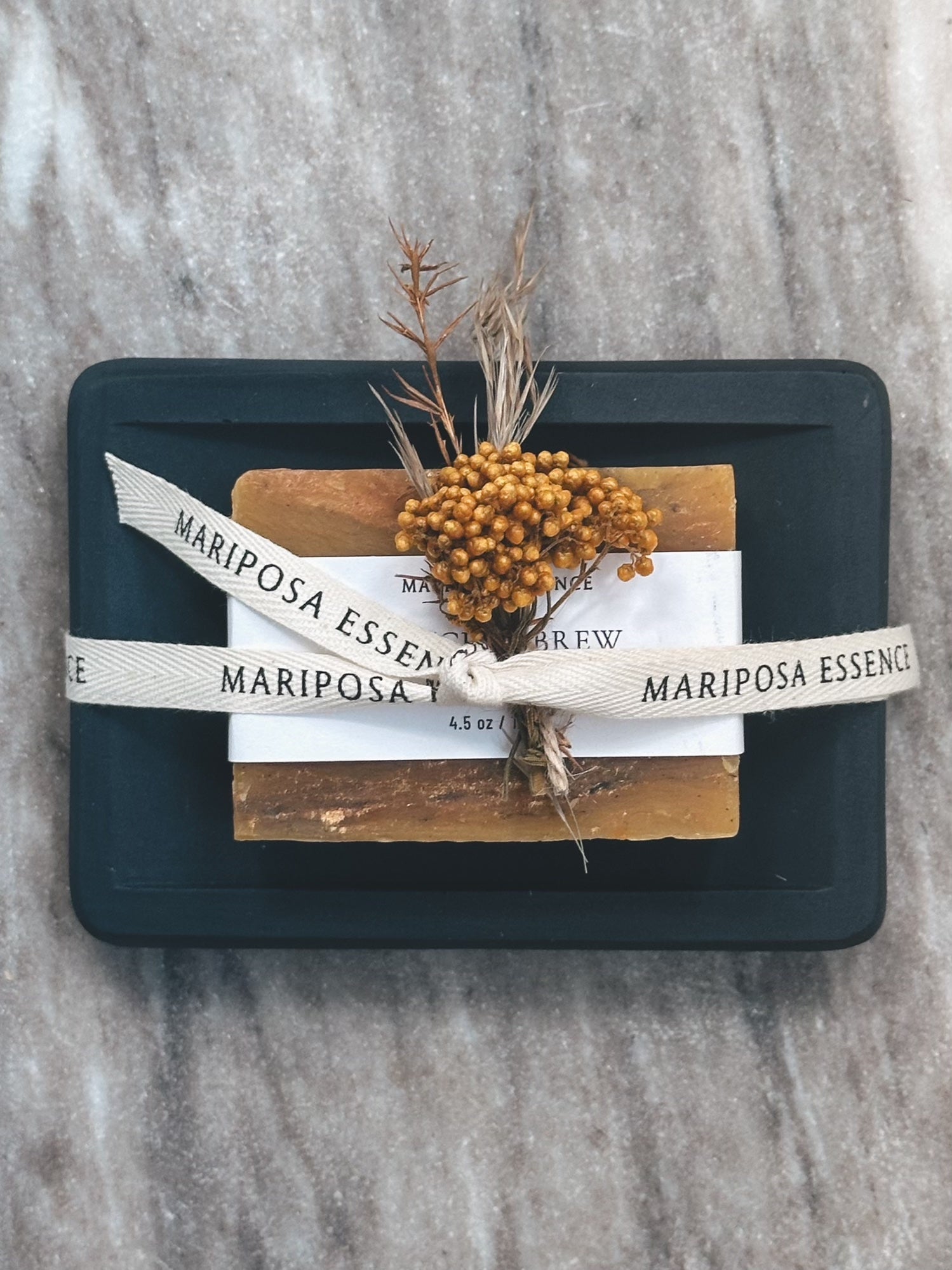 Witches Brew soap on black soap dish styled with dried florals.