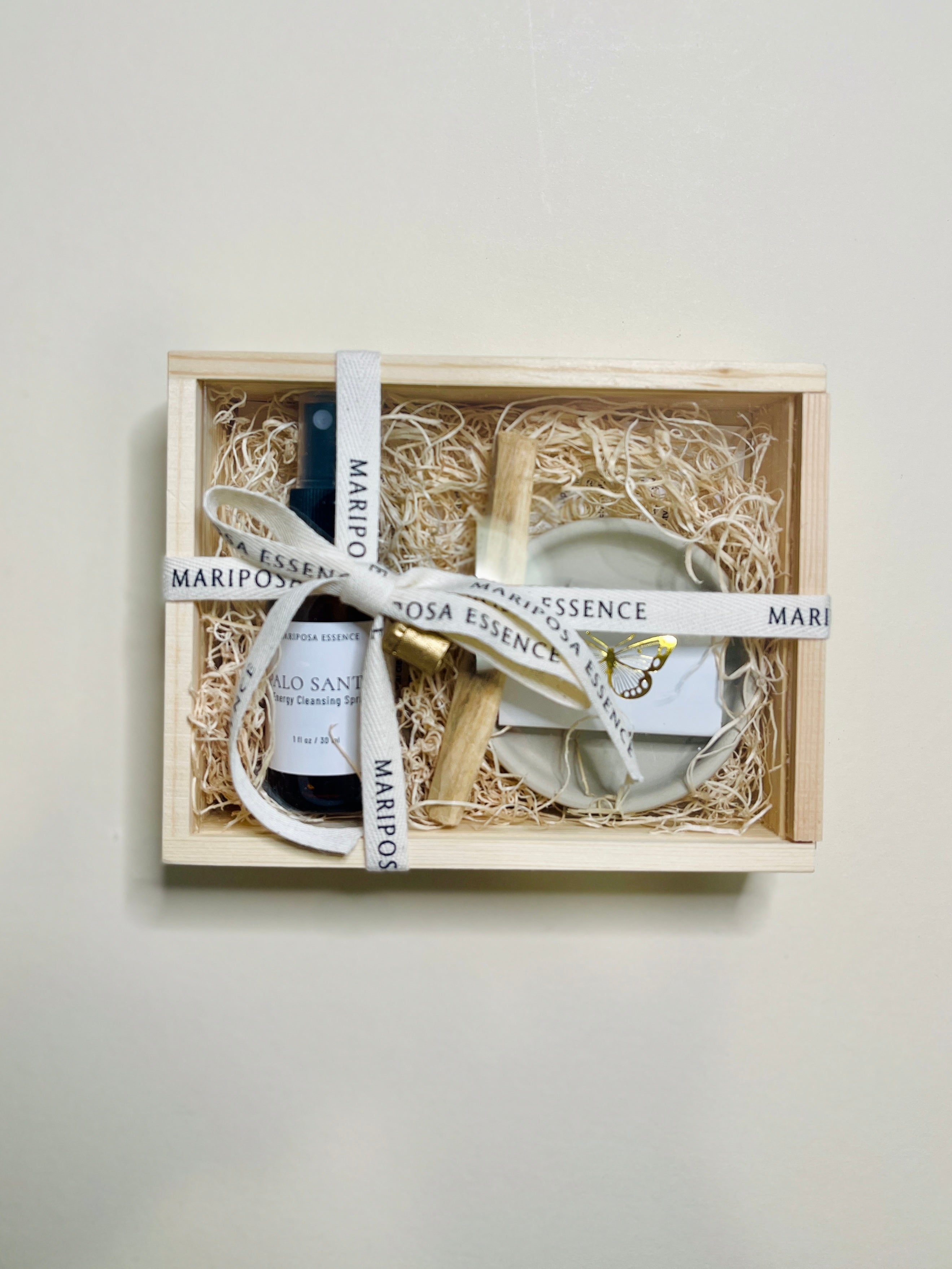 Palo Santo mini kit with spray, stick, holder and matches with butterfly imprinted in foiled gold.
