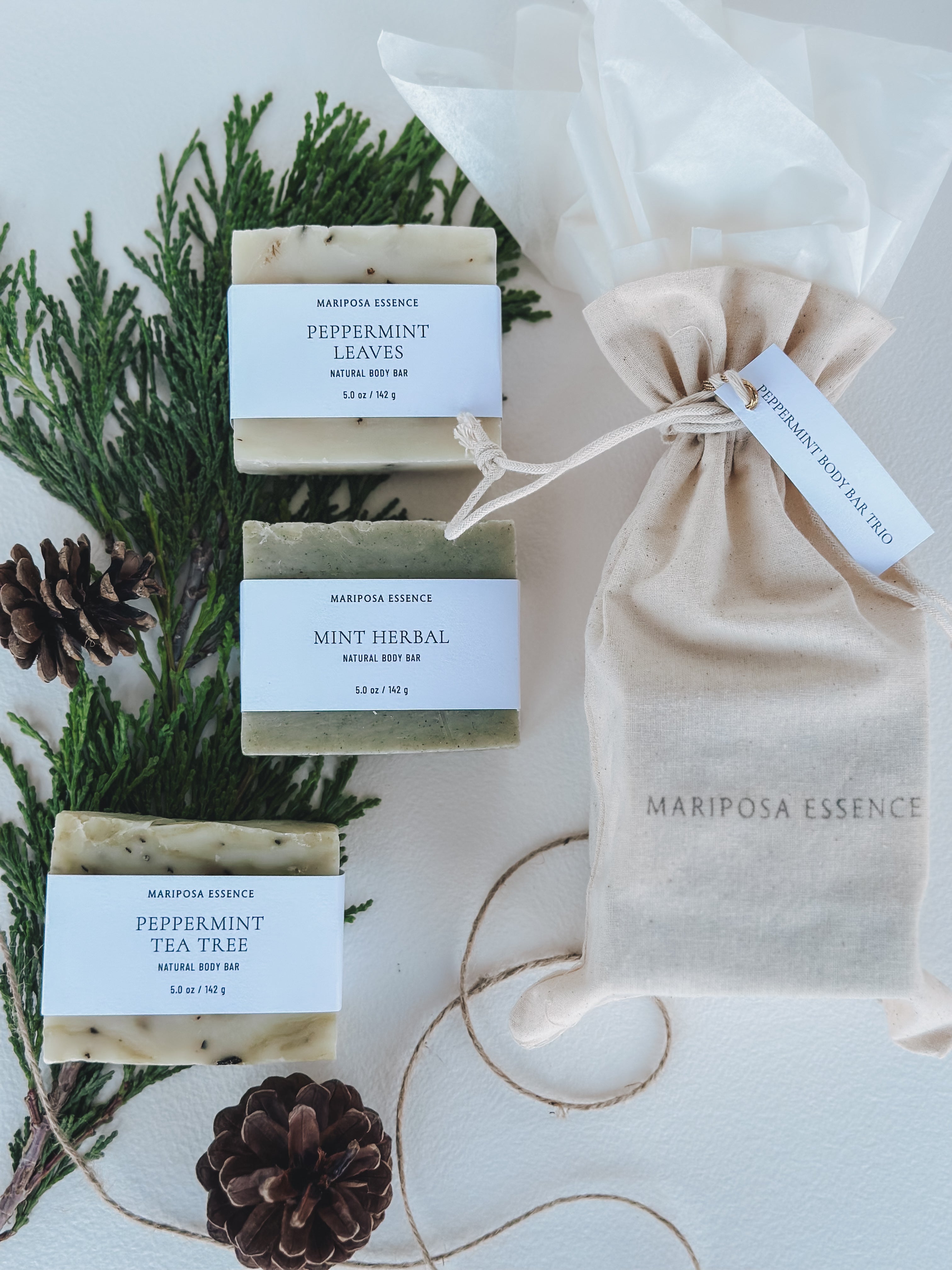Peppermint Body Bar Trio giftwrapped with tissue and a muslin bag displayed with cypress and pinecones